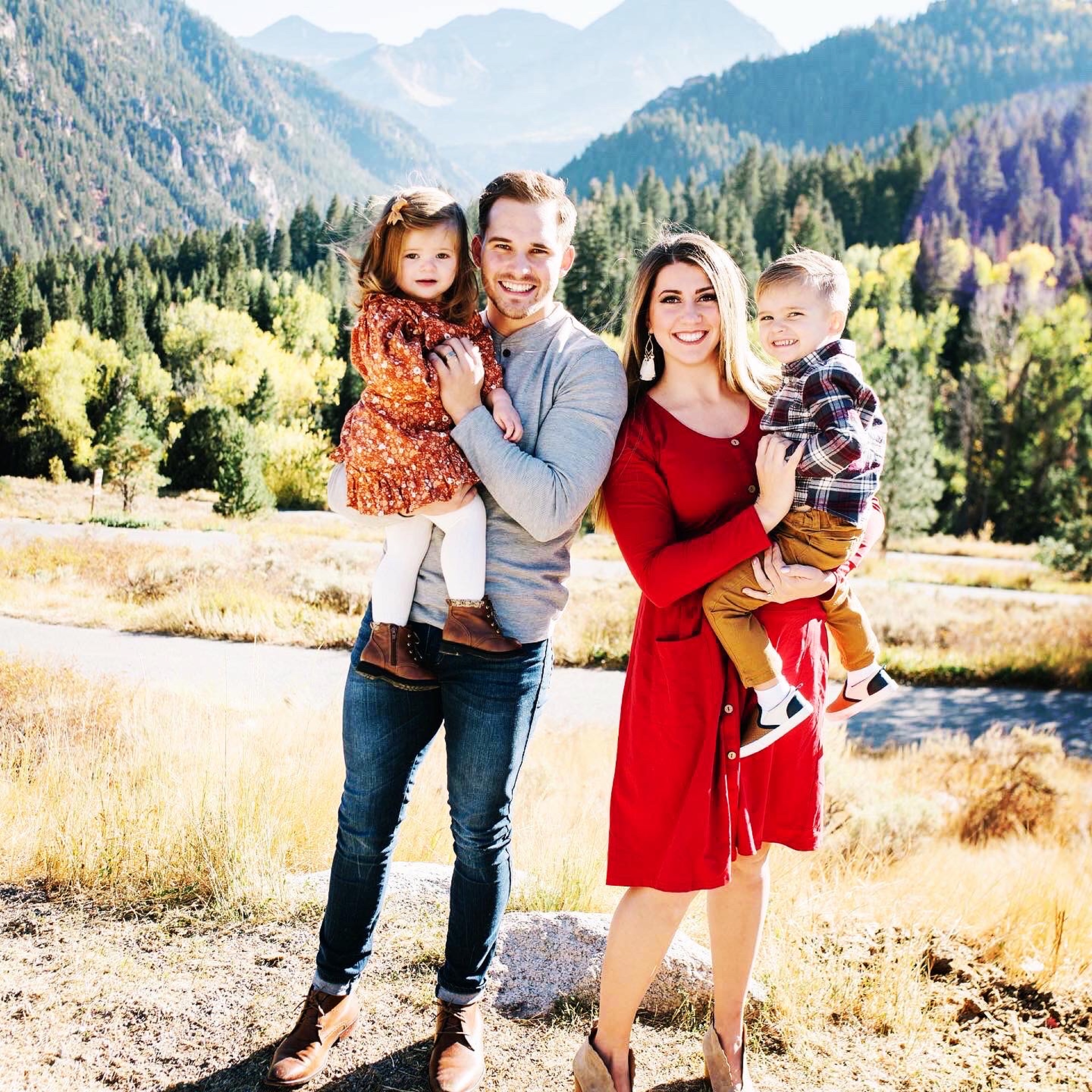 A family together in warm light with mountains behind them